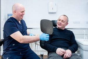 Dentist showing a patient their smile during a cosmetic dental consultation.