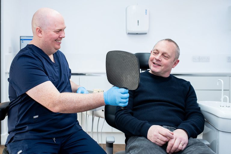 Dentist showing a patient their smile during a cosmetic dental consultation.